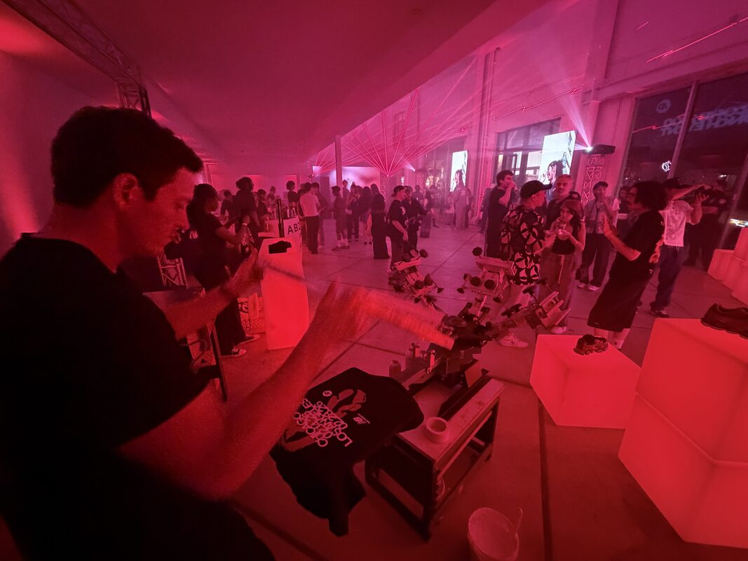 Crowded evening brand event with a live personalization station running under red lighting